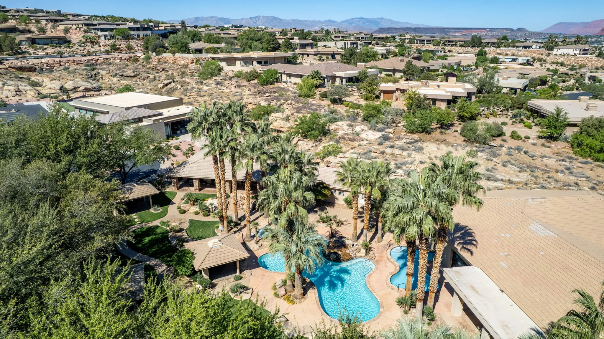Aerial perspective of suburban area with mountains and a pool area