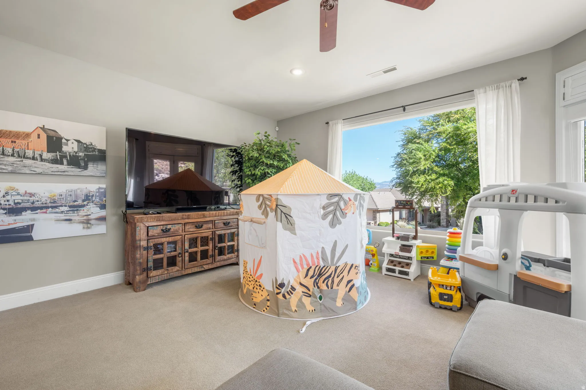 Carpeted living room with a ceiling fan and recessed lighting