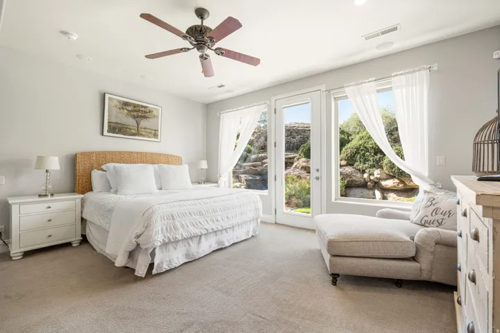 Carpeted bedroom with access to outside and ceiling fan