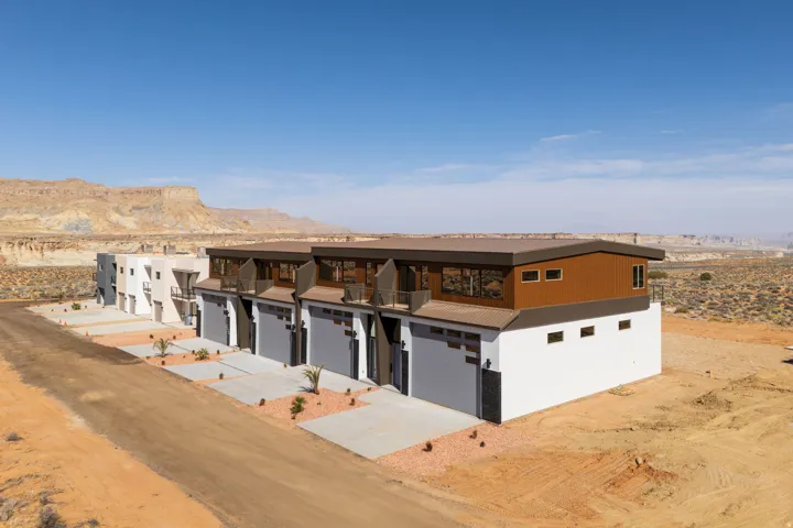 View of front of property featuring concrete driveway, a mountain view, a balcony, and a desert view