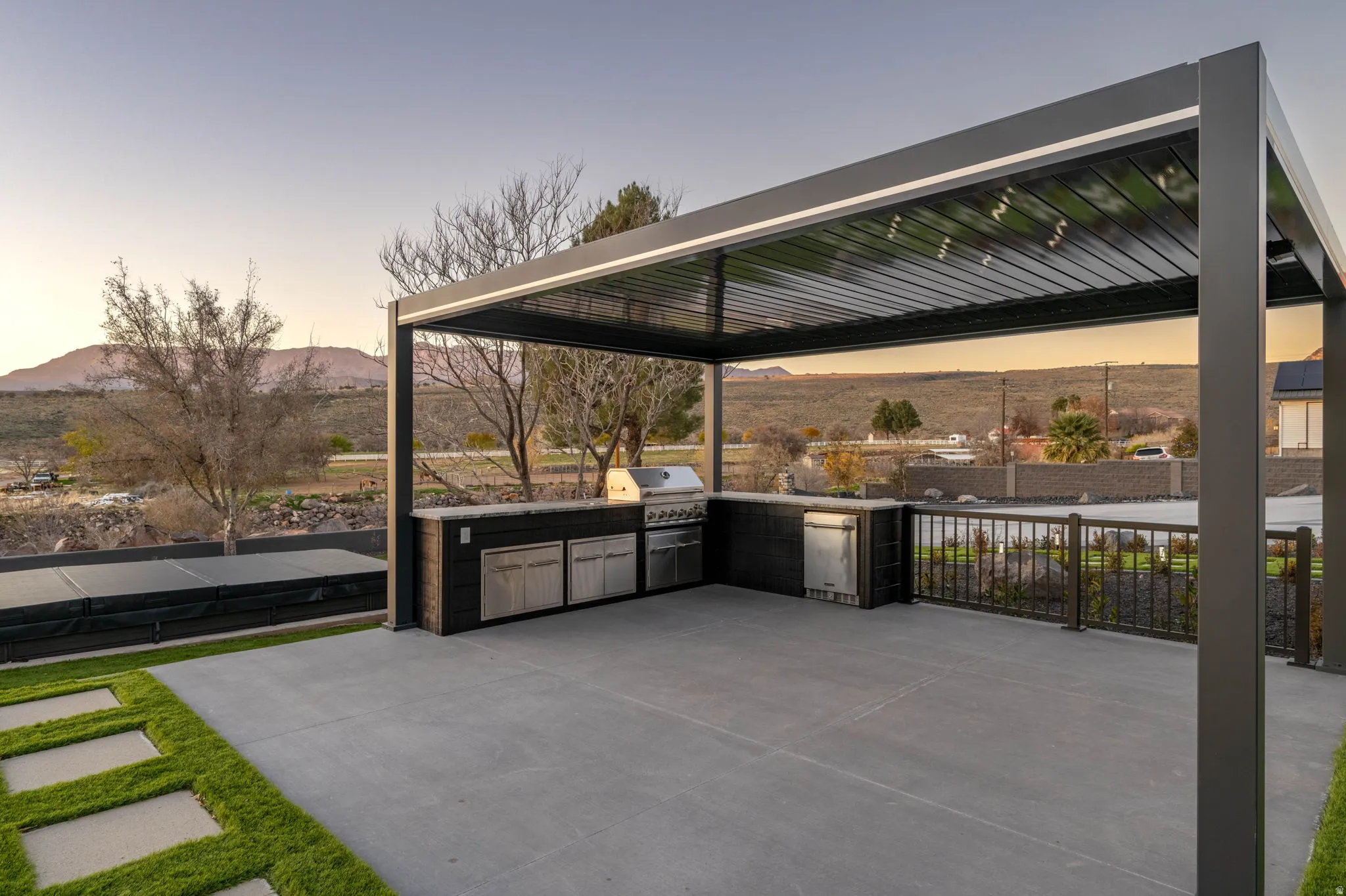 Patio terrace at dusk featuring area for grilling, a mountain view, and a patio area