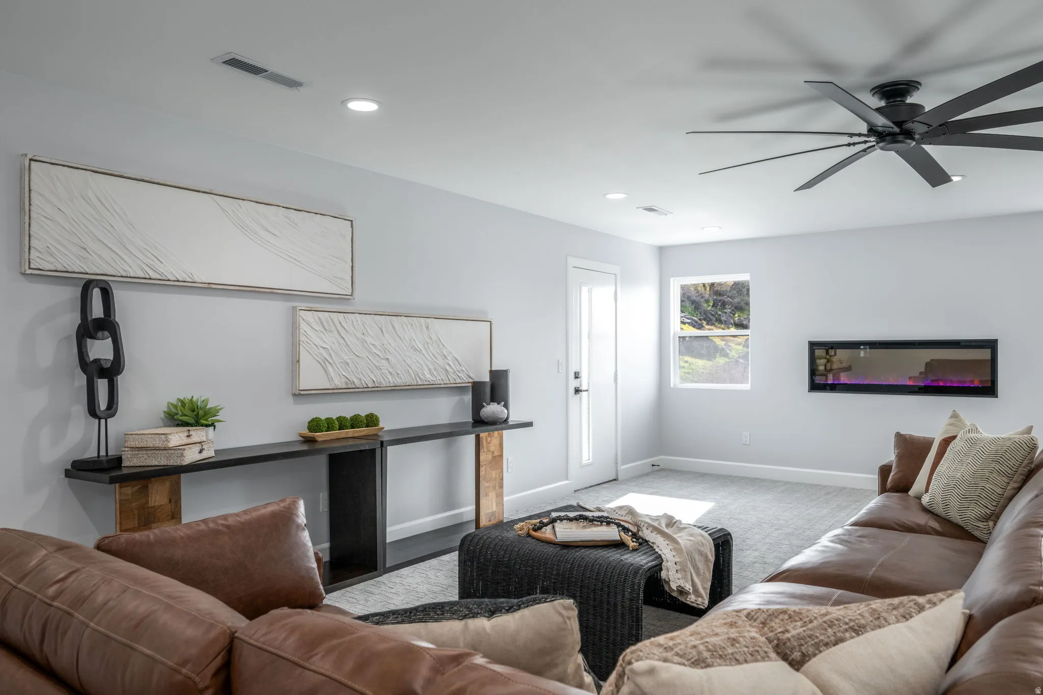 Carpeted living area with ceiling fan and recessed lighting