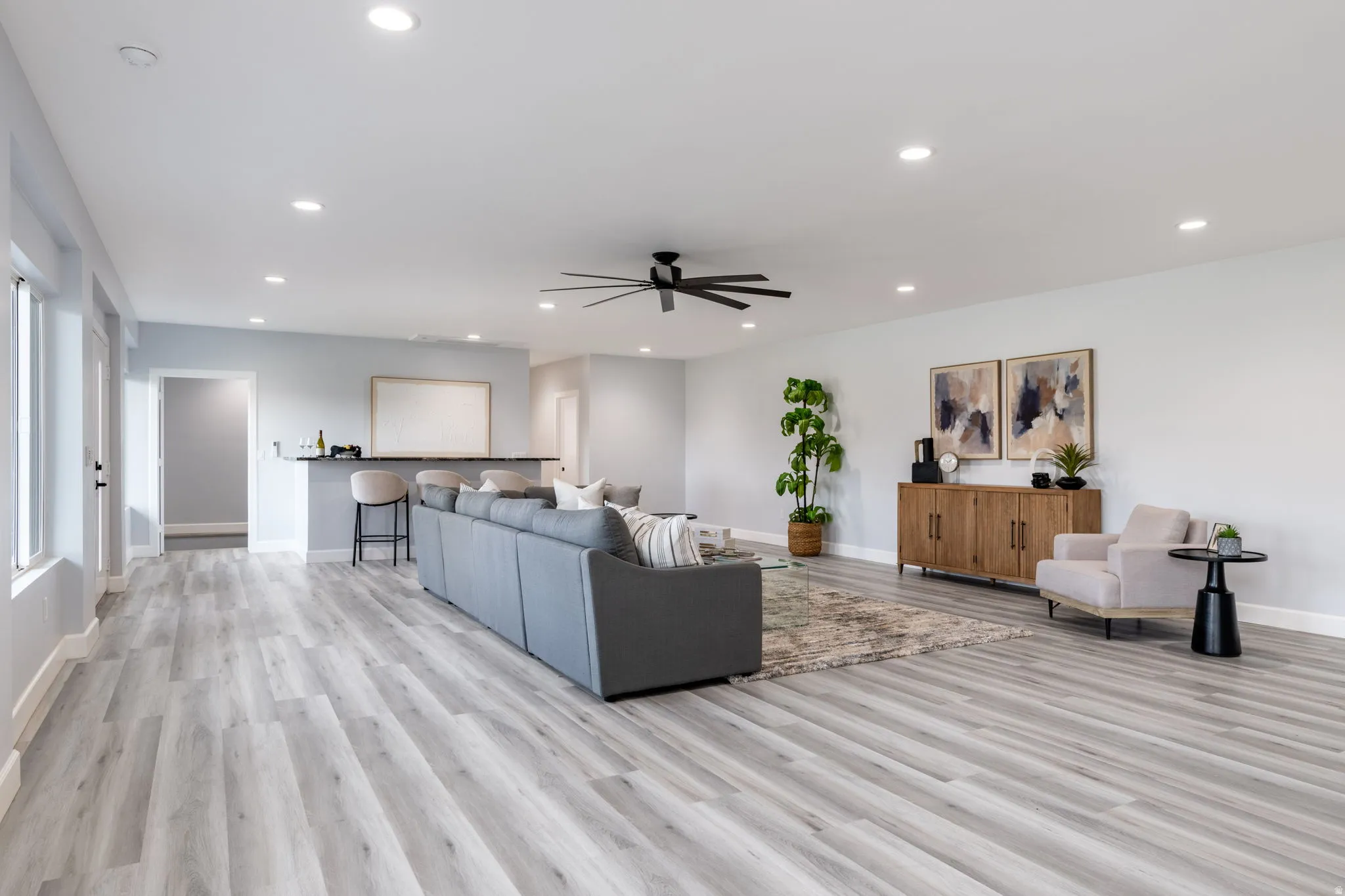 Living room with ceiling fan, light wood finished floors, and recessed lighting