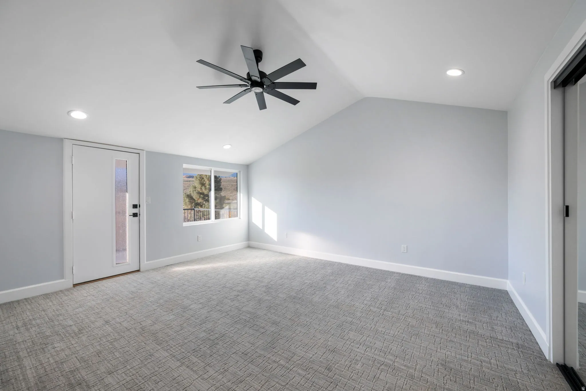 Unfurnished living room featuring carpet floors, recessed lighting, ceiling fan, and vaulted ceiling
