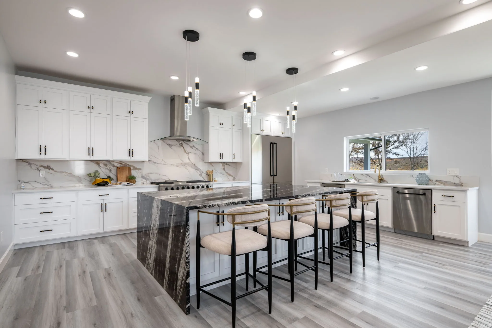 Kitchen featuring dark stone countertops, white cabinets, a breakfast bar, and light wood-style floors