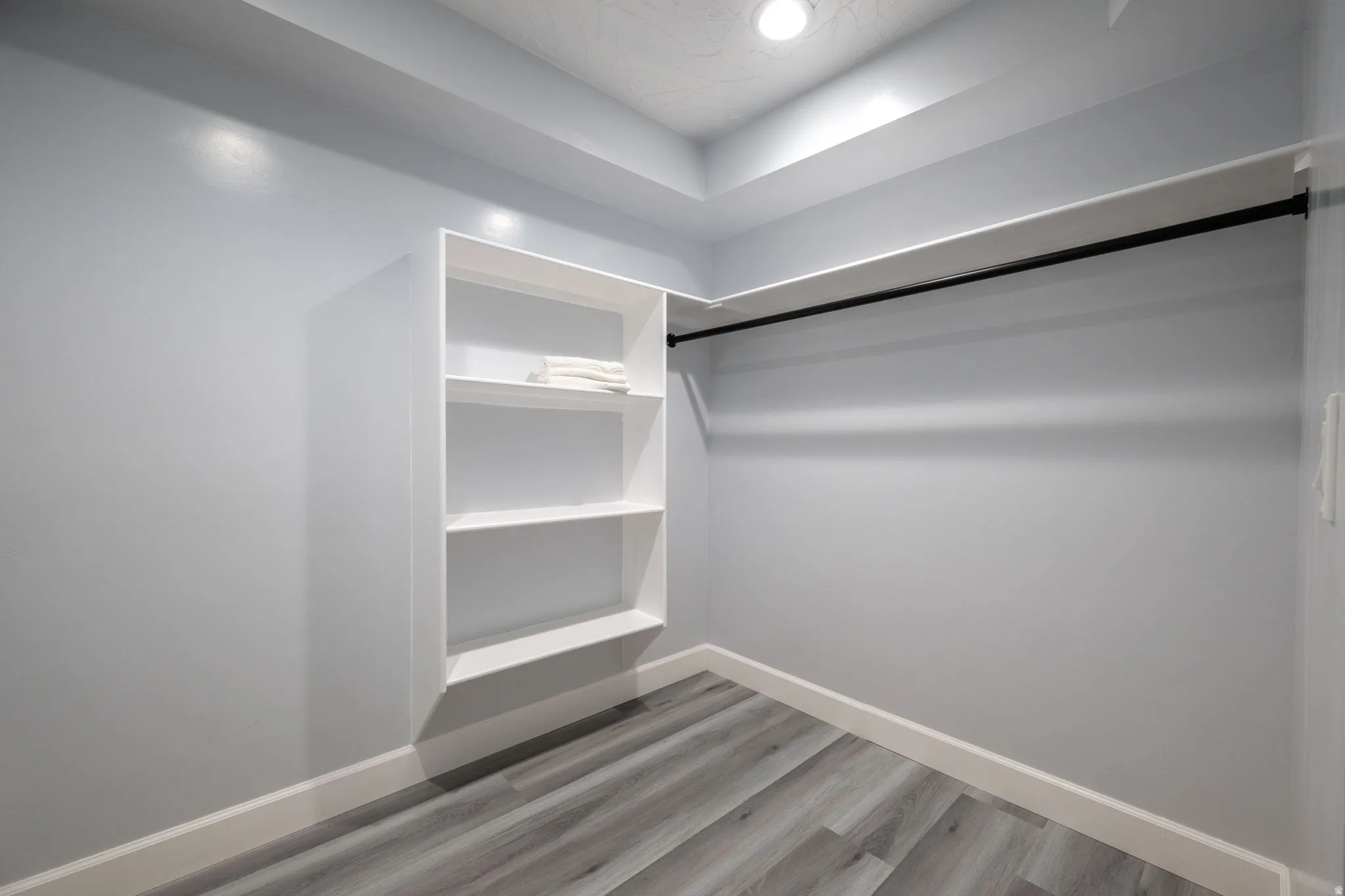 Walk in closet featuring light wood-style flooring
