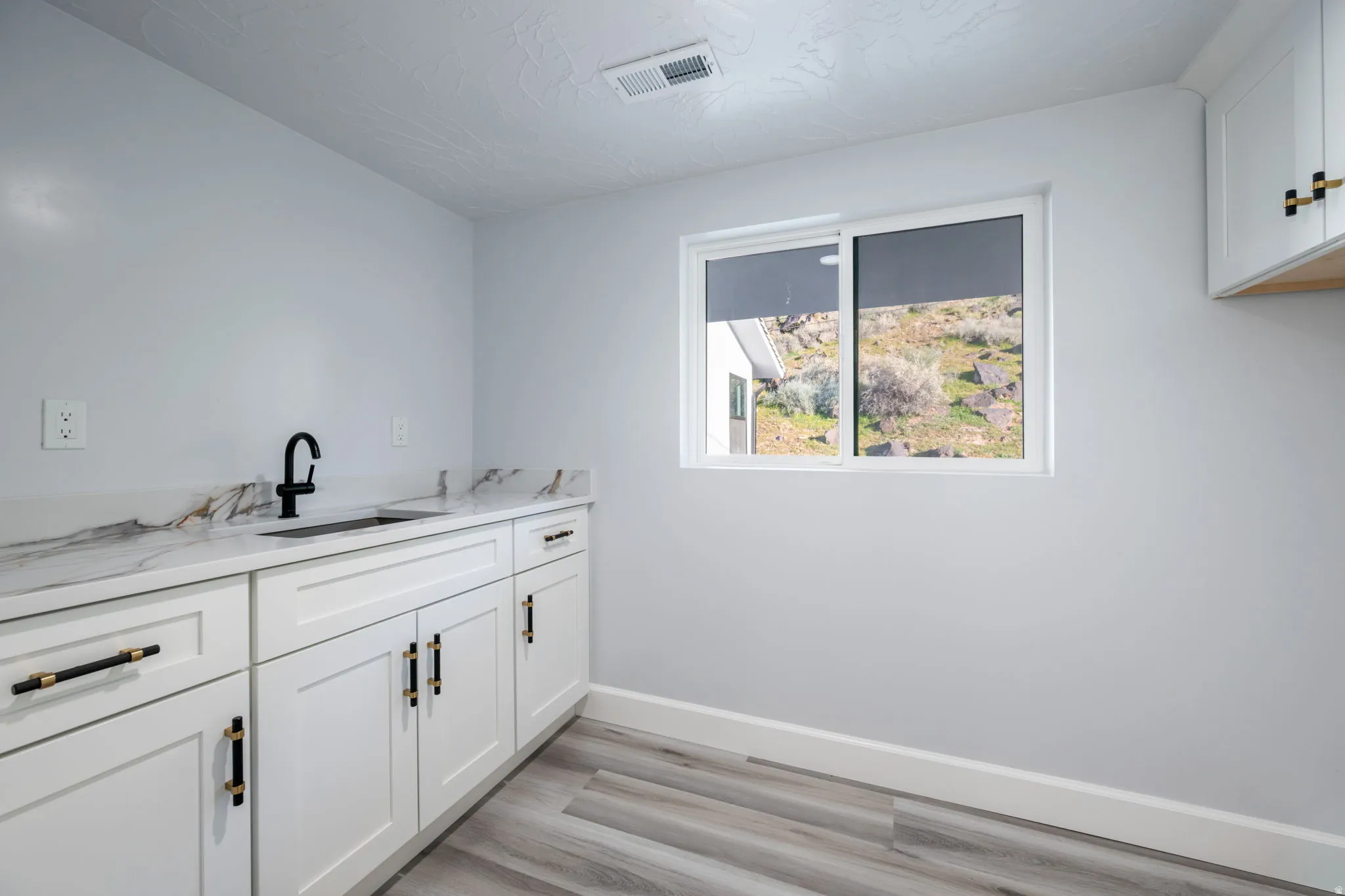 Laundry room featuring light wood-type flooring and cabinet space