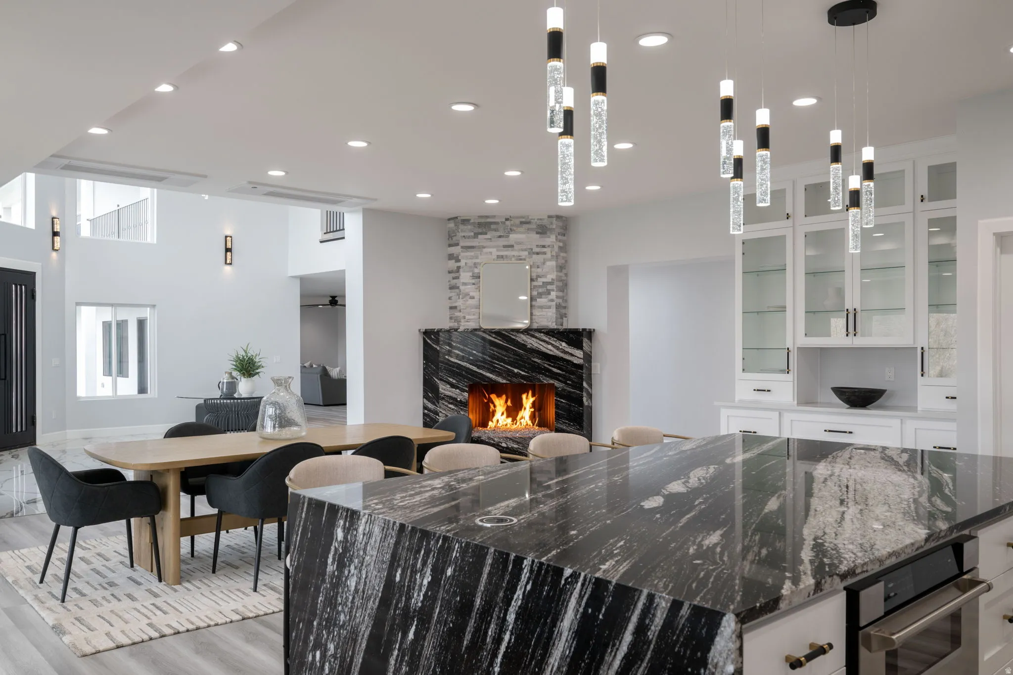 Kitchen with white cabinetry, dark stone counters, oven, a large fireplace, and a kitchen island