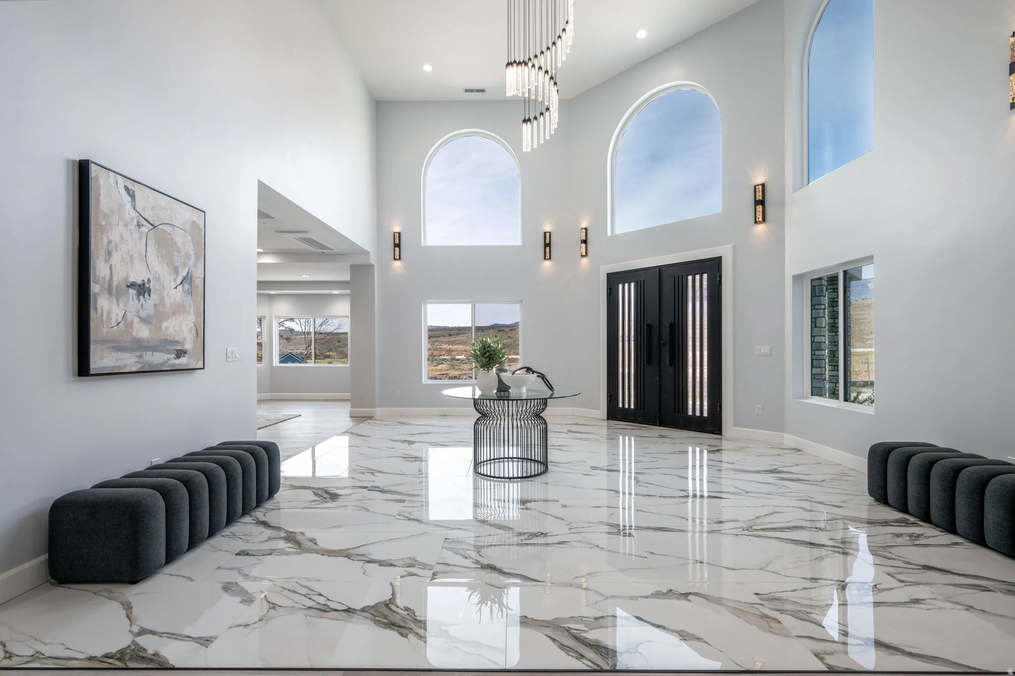 Foyer entrance with light marble finish floors, healthy amount of natural light, recessed lighting, and a high ceiling