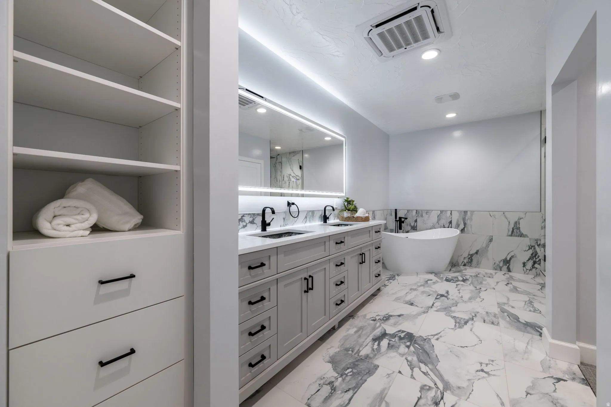 Full bathroom with a wainscoted wall, tile walls, double vanity, a soaking tub, and recessed lighting