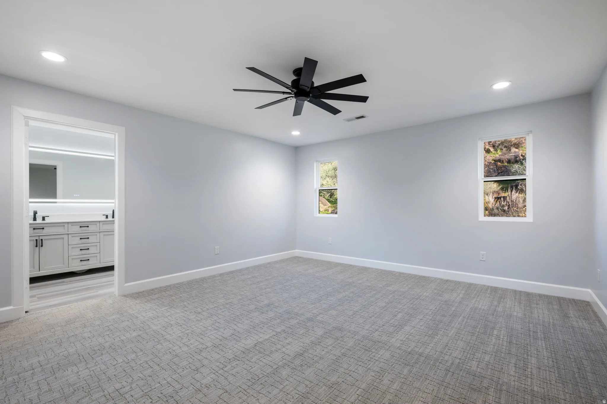 Carpeted spare room featuring ceiling fan and recessed lighting