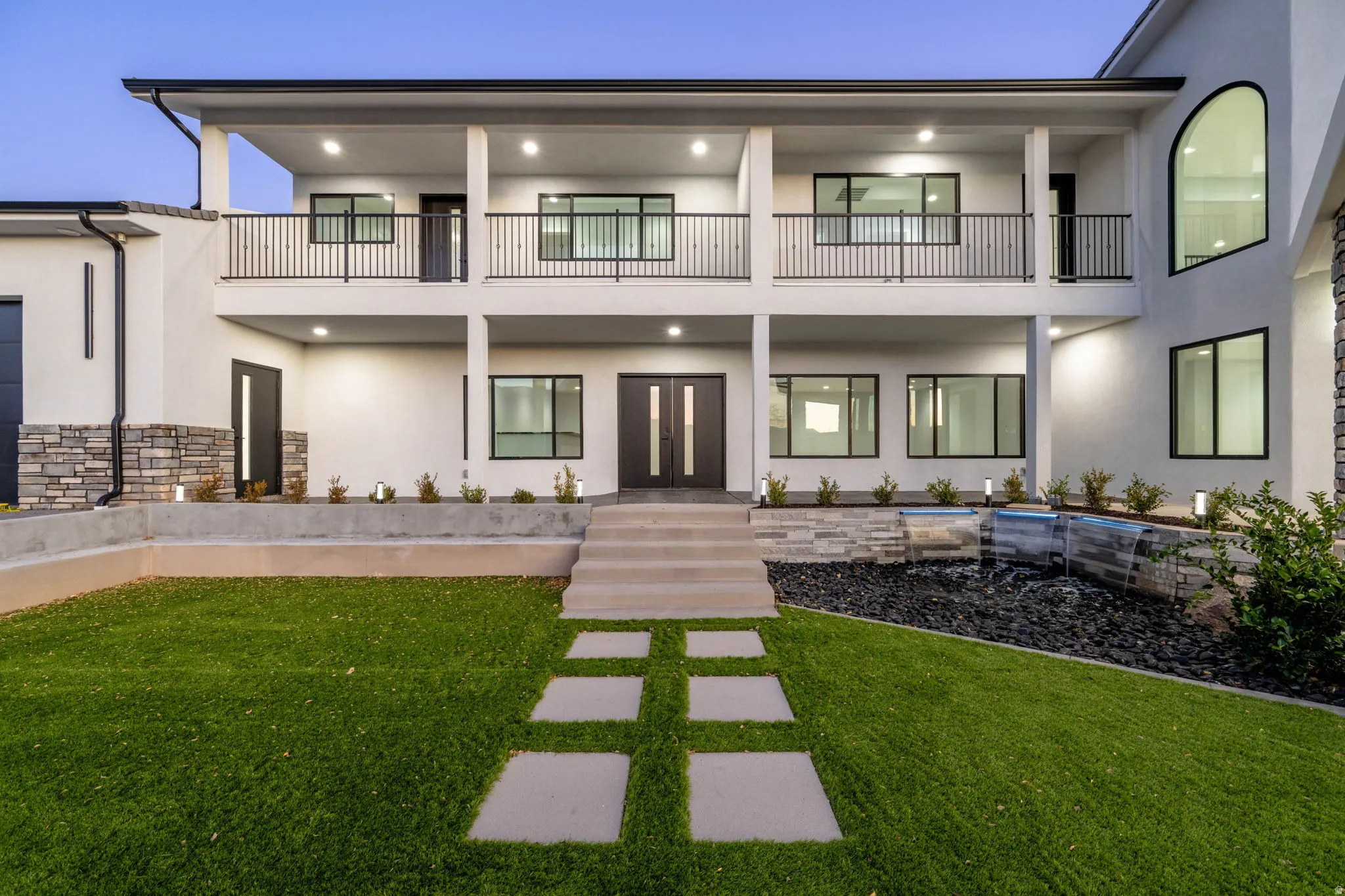 Rear view of house featuring stucco siding, french doors, and a yard
