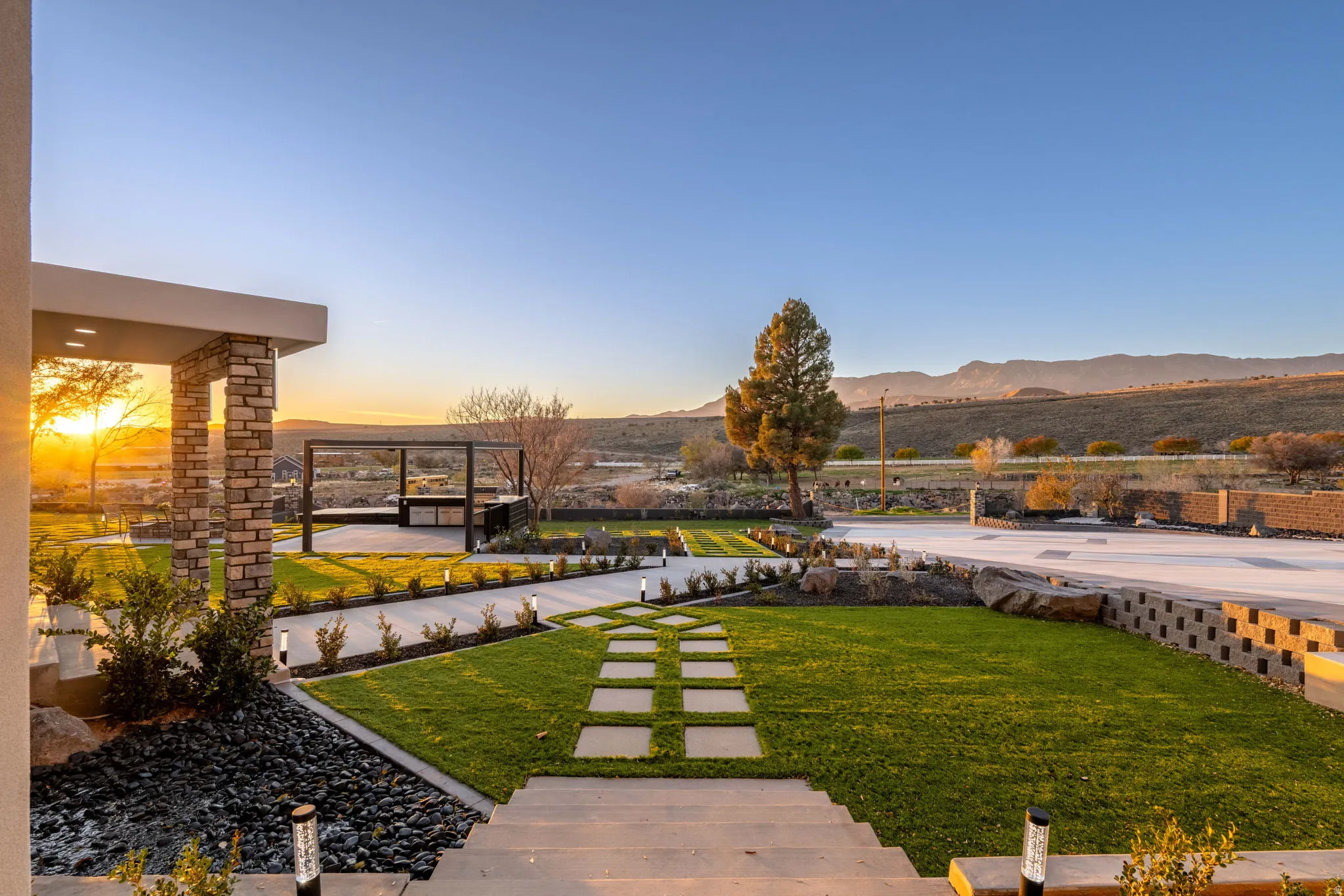 Yard at dusk featuring a lawn, a mountain view, and a patio