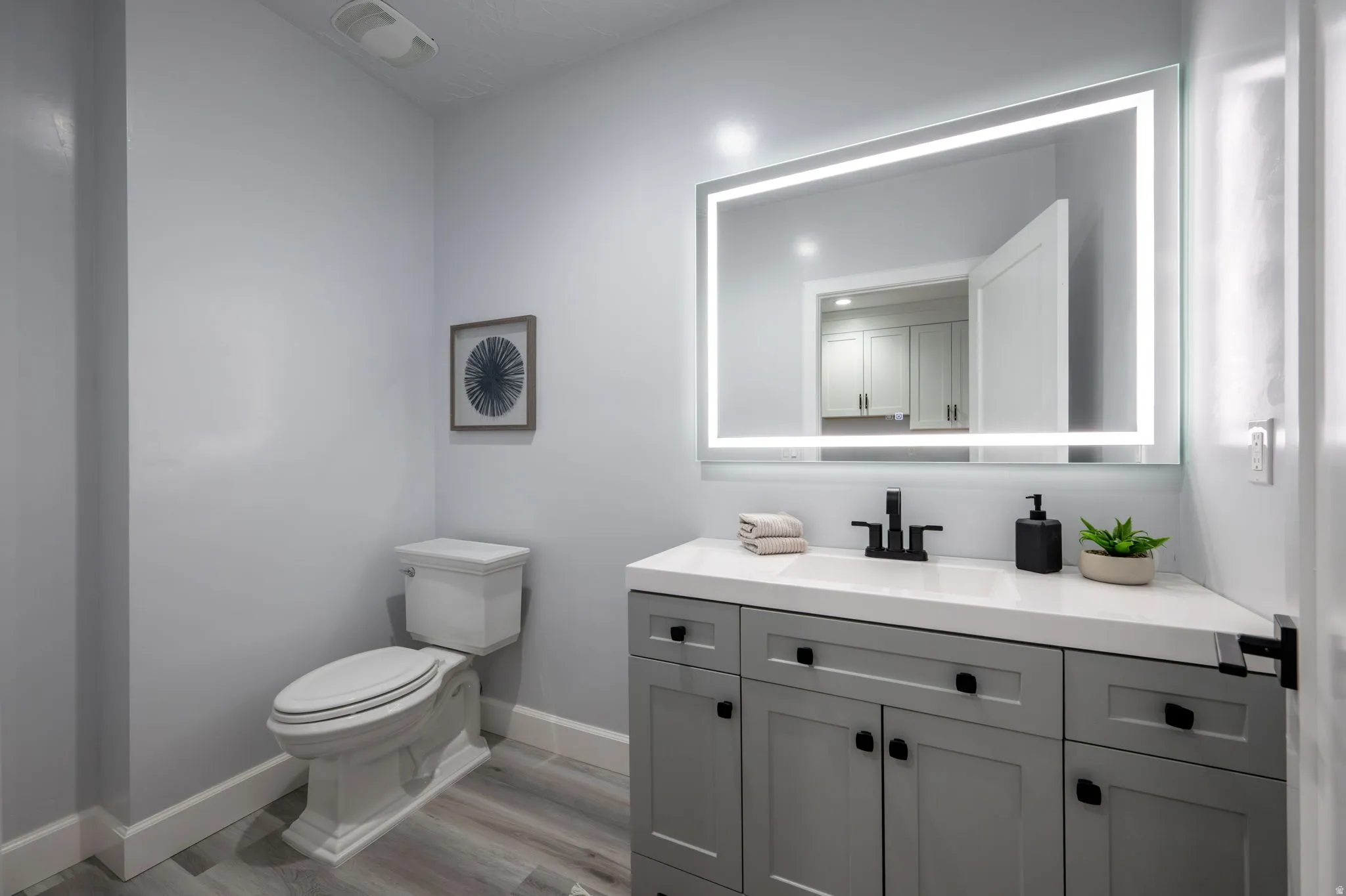 Half bathroom featuring vanity and light wood-style flooring