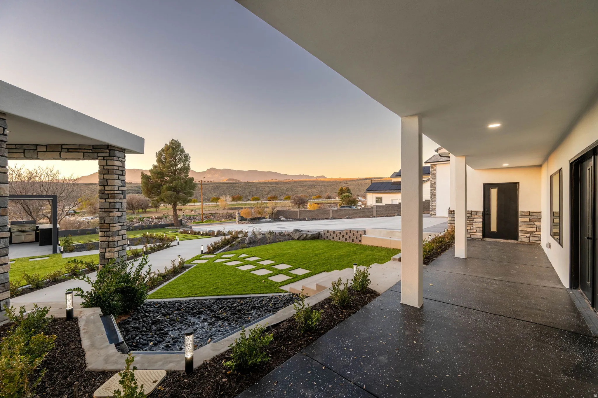 Yard at dusk with a mountain view, a yard, and a patio