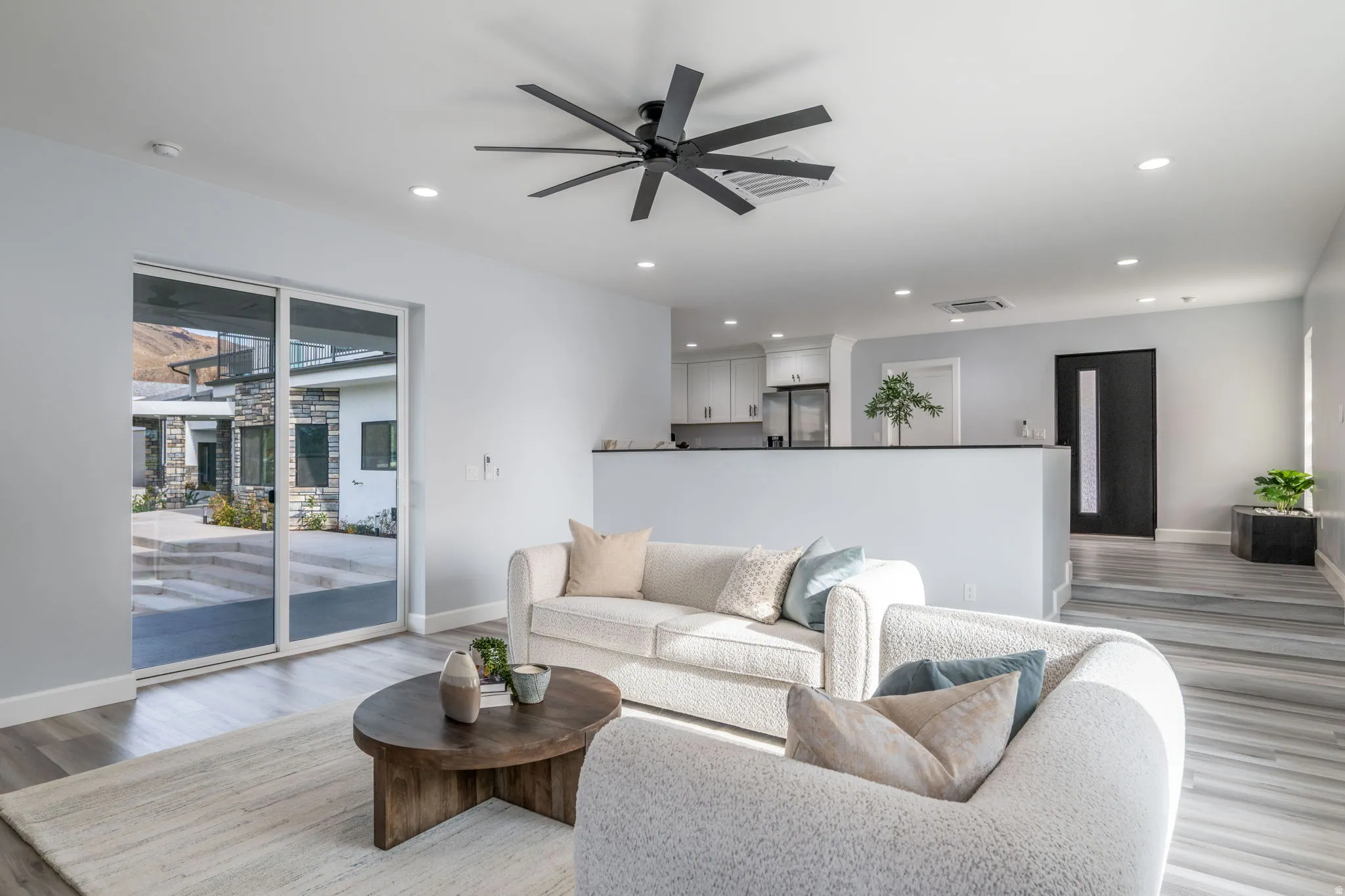 Living room with ceiling fan, light wood-type flooring, and recessed lighting