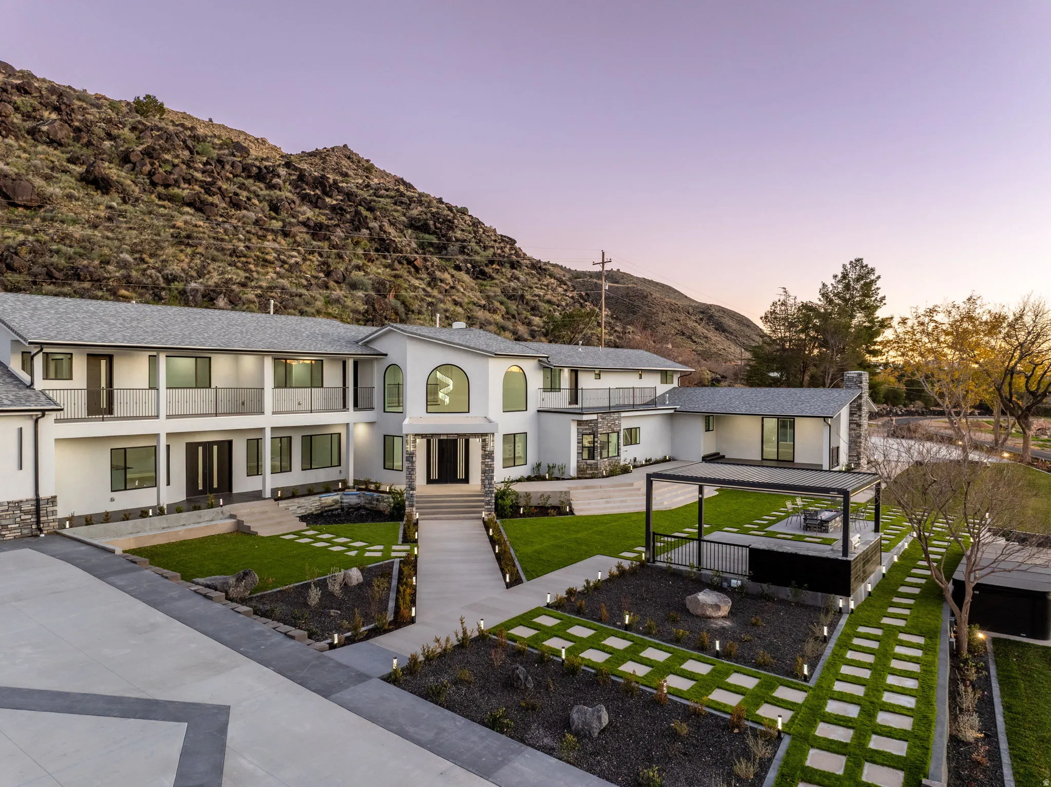 View of front of house with stucco siding, a mountain view, and a front yard
