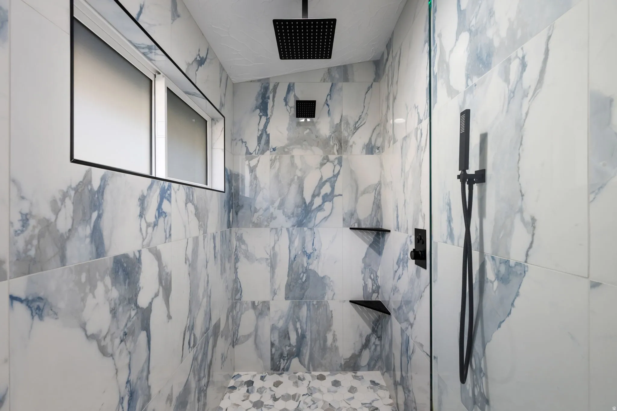 Bathroom featuring a marble finish shower