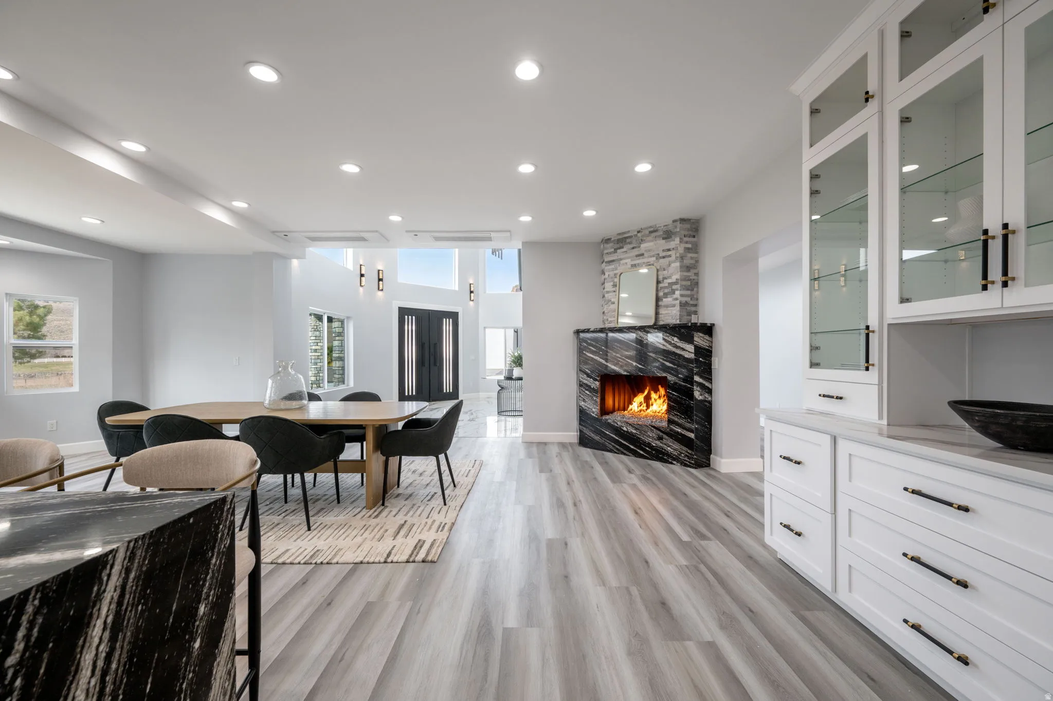 Dining space featuring a large fireplace, light wood-type flooring, and recessed lighting