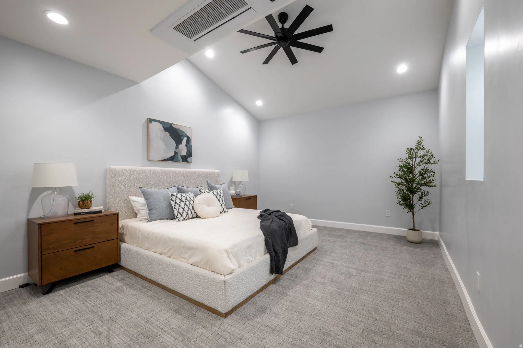 Bedroom with light carpet, ceiling fan, vaulted ceiling, and recessed lighting