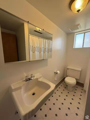Full bathroom with toilet and a shower with curtain
