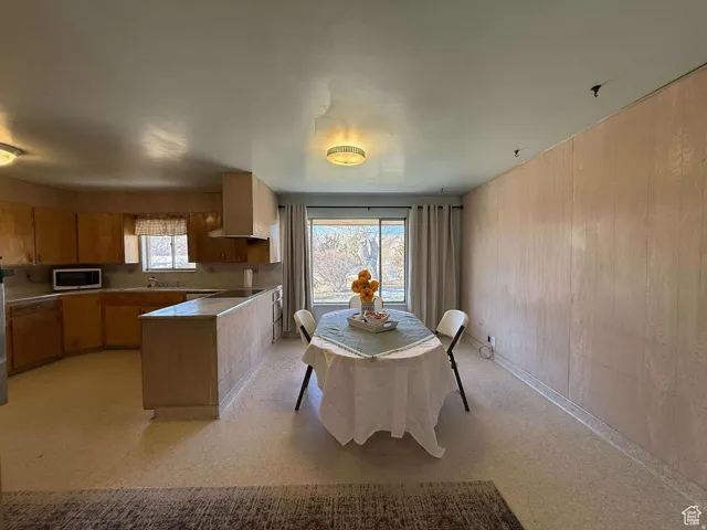 Dining space featuring wood walls and light floors