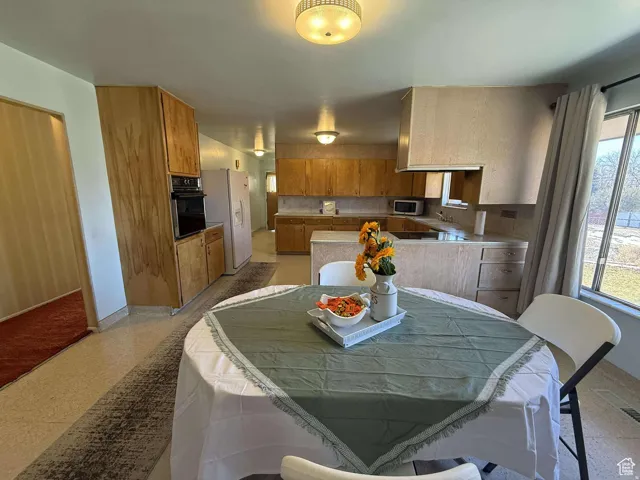 Dining room featuring light flooring and baseboards