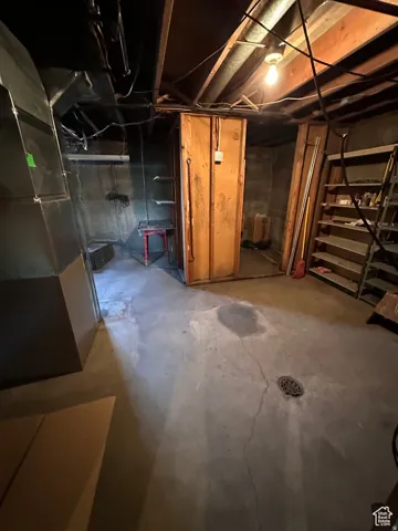 Unfinished basement with stairway and heating unit