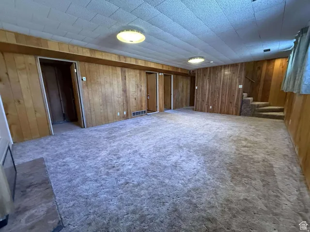 Finished basement with carpet floors and wood walls