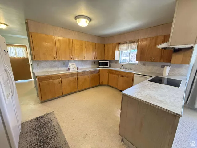 Kitchen with light countertops, wood finish cabinets, and light flooring