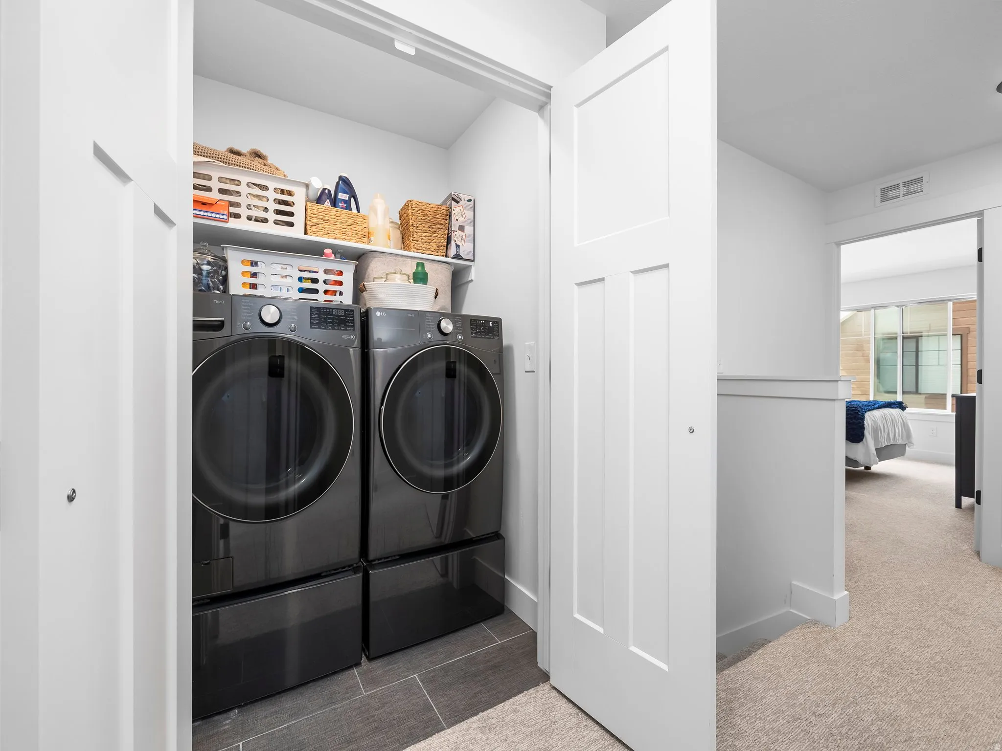 Laundry area with separate washer and dryer and light carpet