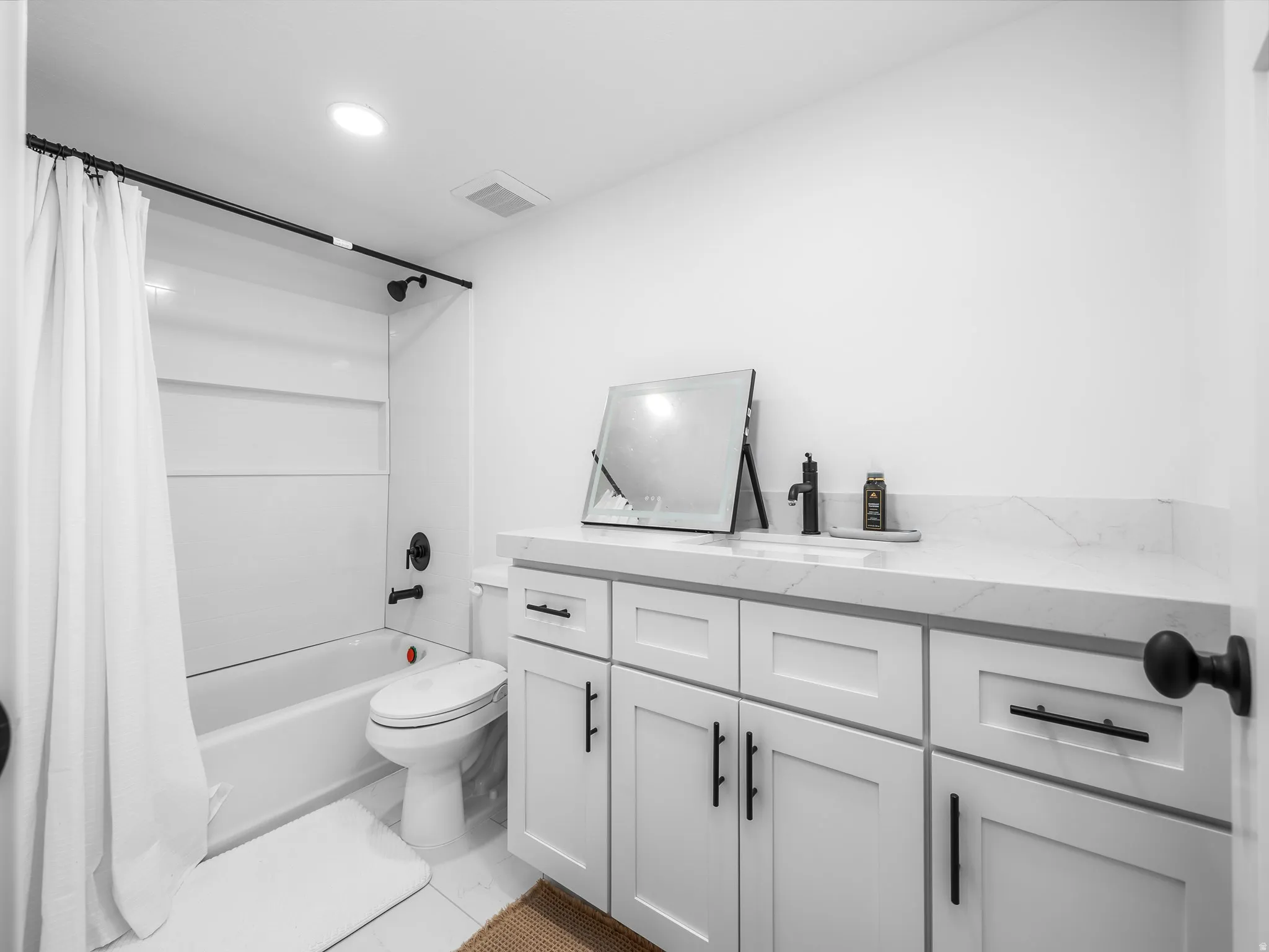 Bathroom featuring vanity, shower / tub combo, and recessed lighting