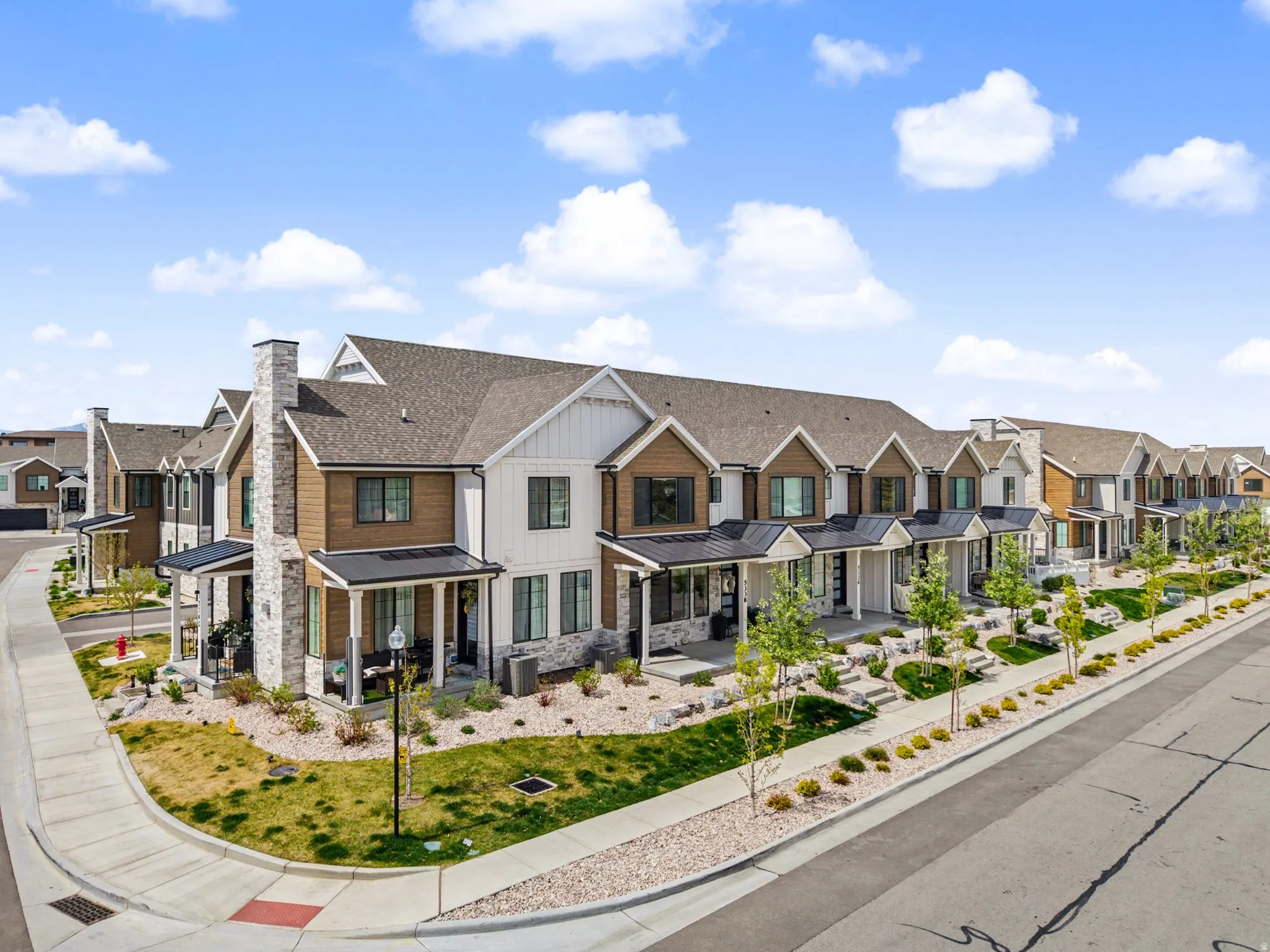 View of front of property with a residential view, board and batten siding, a standing seam roof, covered porch, and stone siding