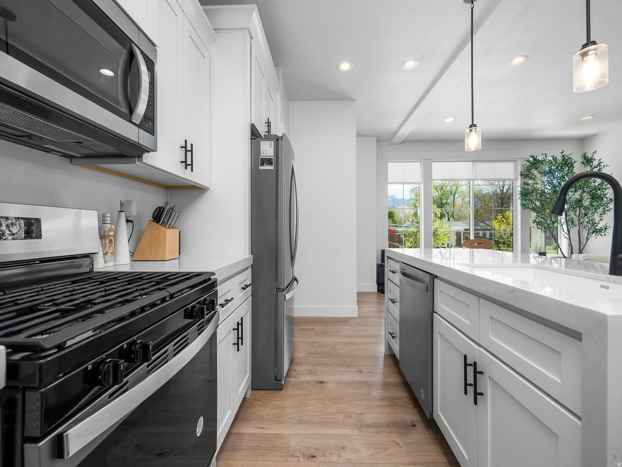 Kitchen featuring stainless steel appliances, white cabinetry, and light wood-style floors