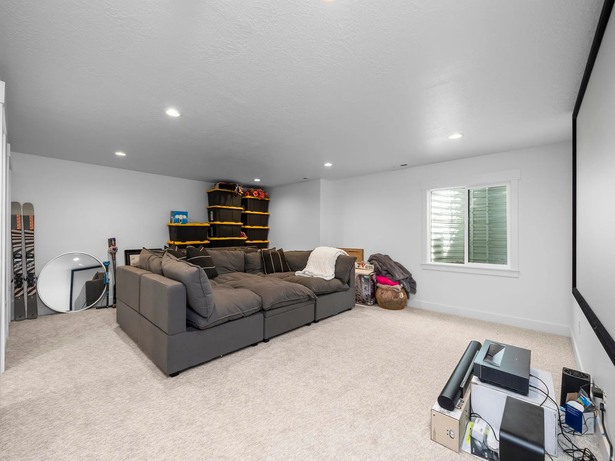 Living area featuring light carpet, recessed lighting, and a textured ceiling