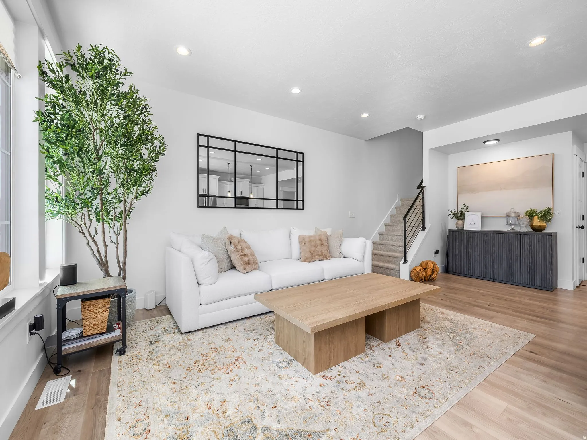Living area with light wood-style flooring and recessed lighting