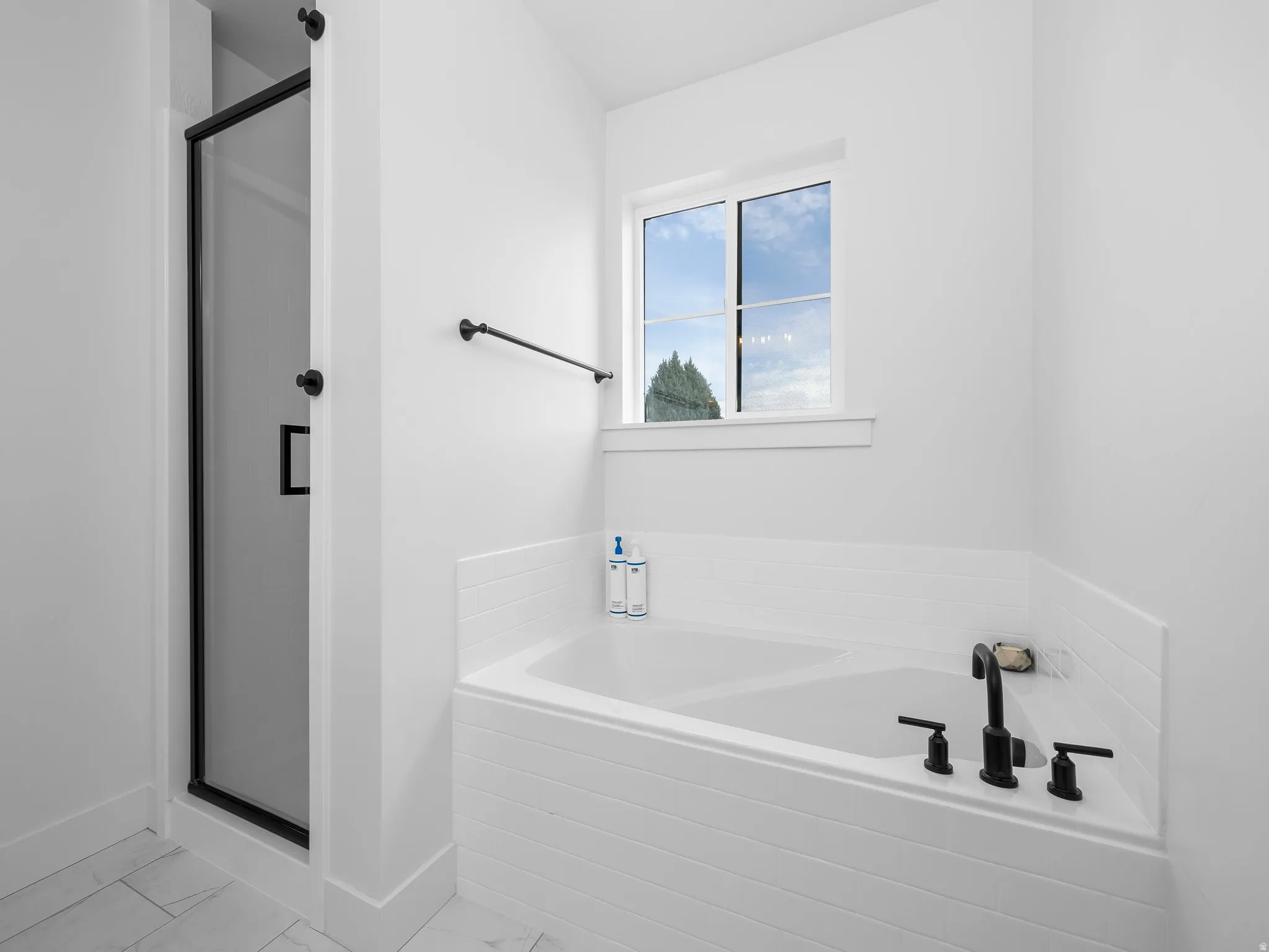 Full bath with a shower stall, a bath, and light marble finish flooring