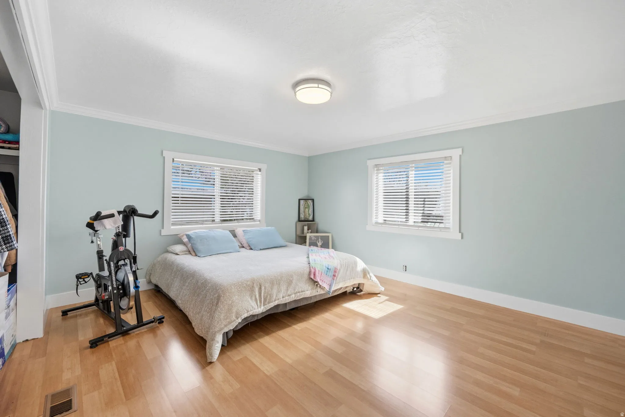 Bedroom featuring light wood-style floors and ornamental molding