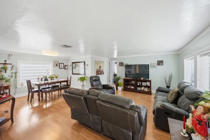 Living area with light wood-style floors and ornamental molding