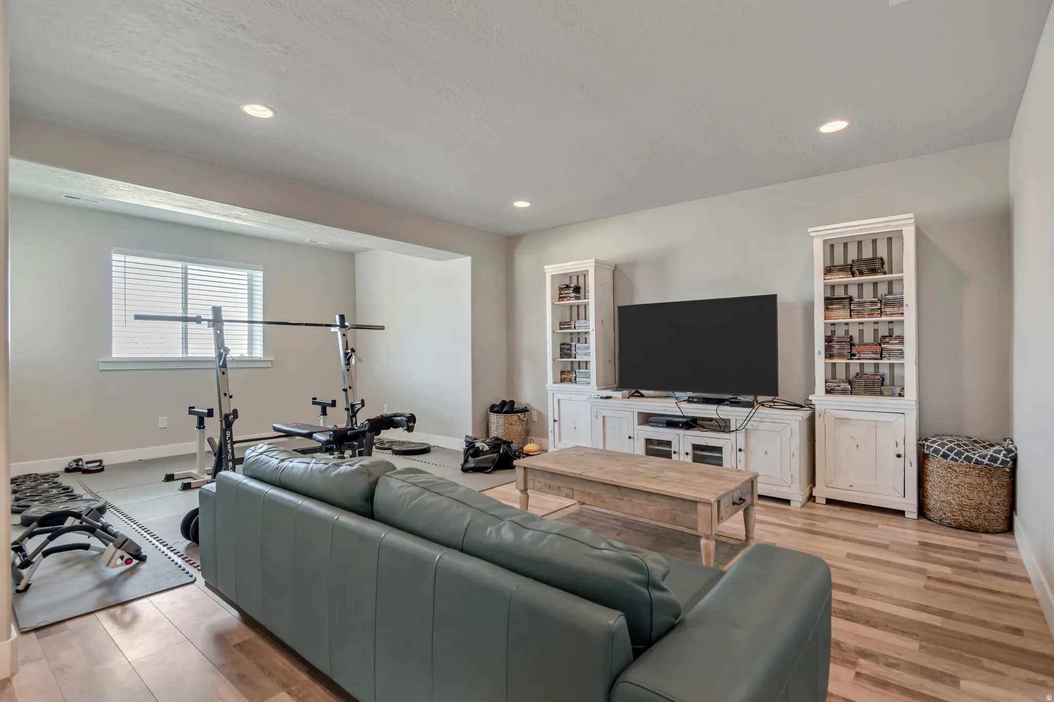 Living room with light wood-style flooring and recessed lighting