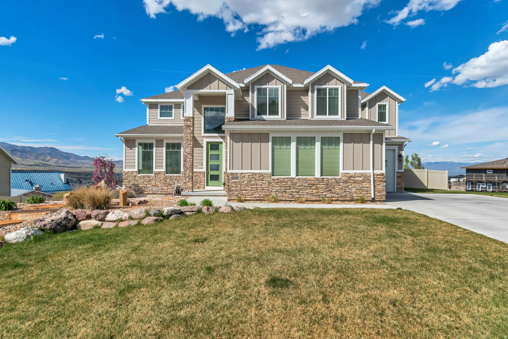 Craftsman-style home with board and batten siding, a mountain view, and stone siding