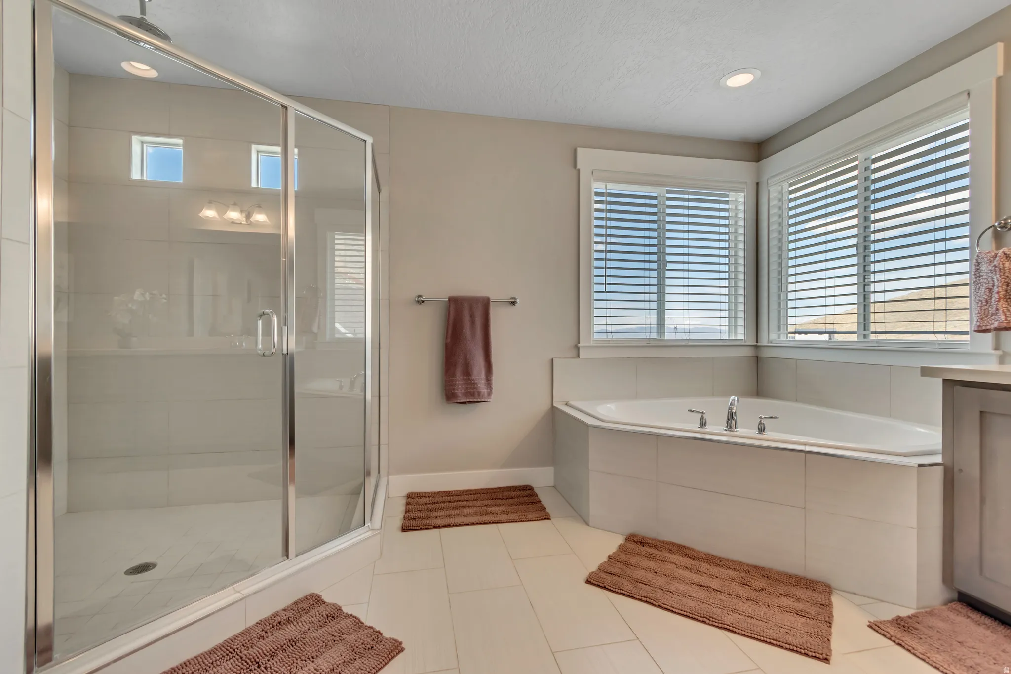 Bathroom featuring a shower stall, vanity, a garden tub, light tile patterned flooring, and recessed lighting