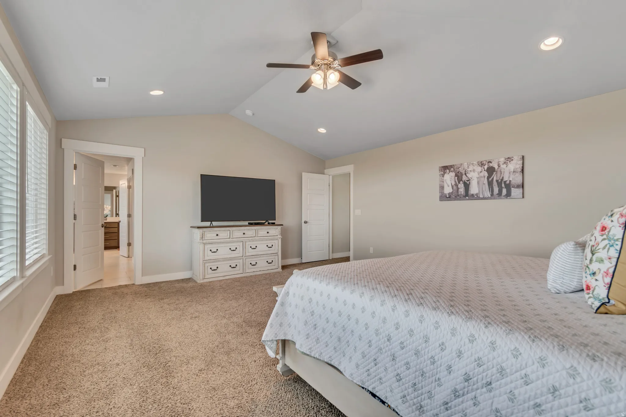 Bedroom featuring light carpet, recessed lighting, ceiling fan, and ensuite bathroom