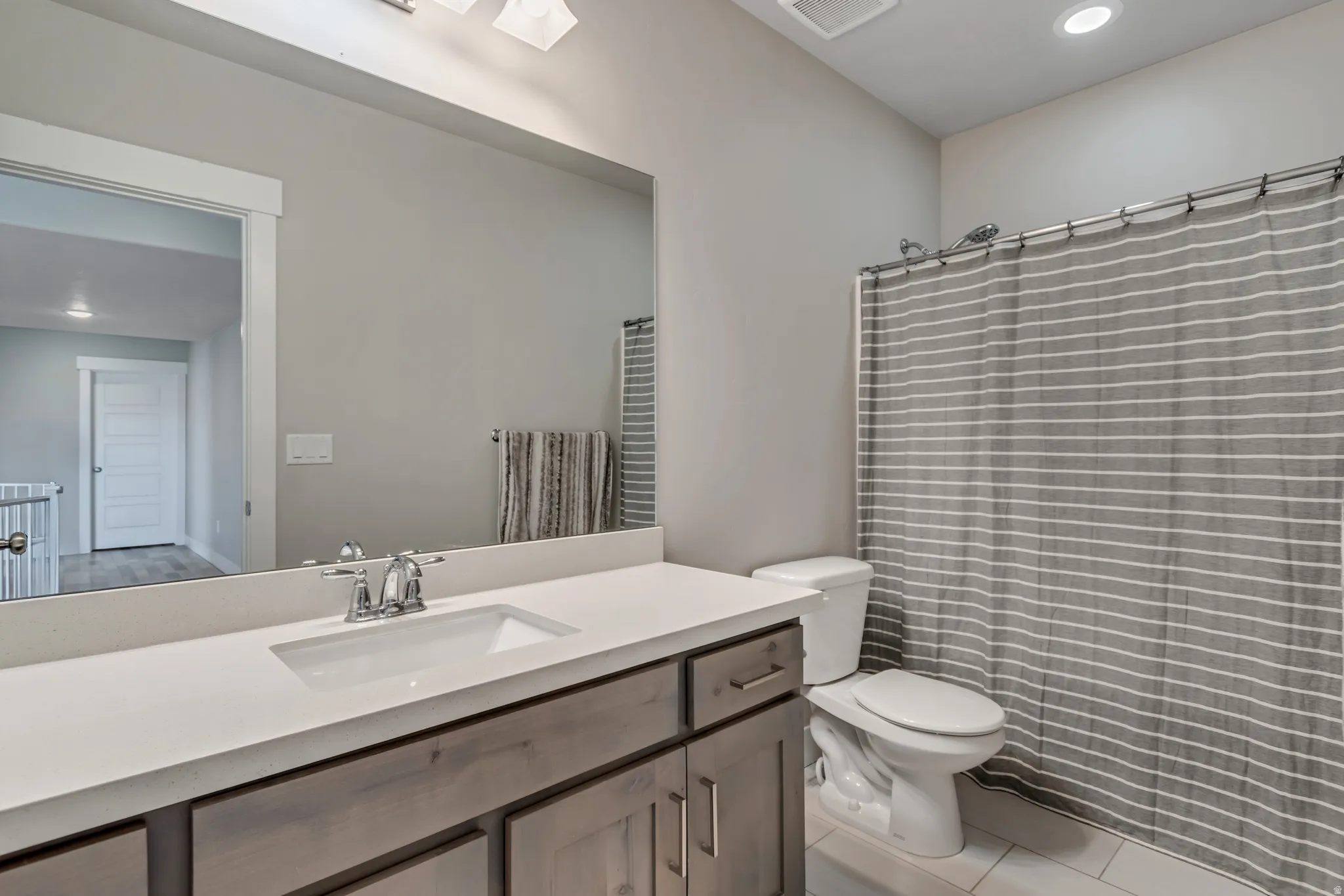 Full bath with recessed lighting, vanity, curtained shower, and light tile patterned flooring