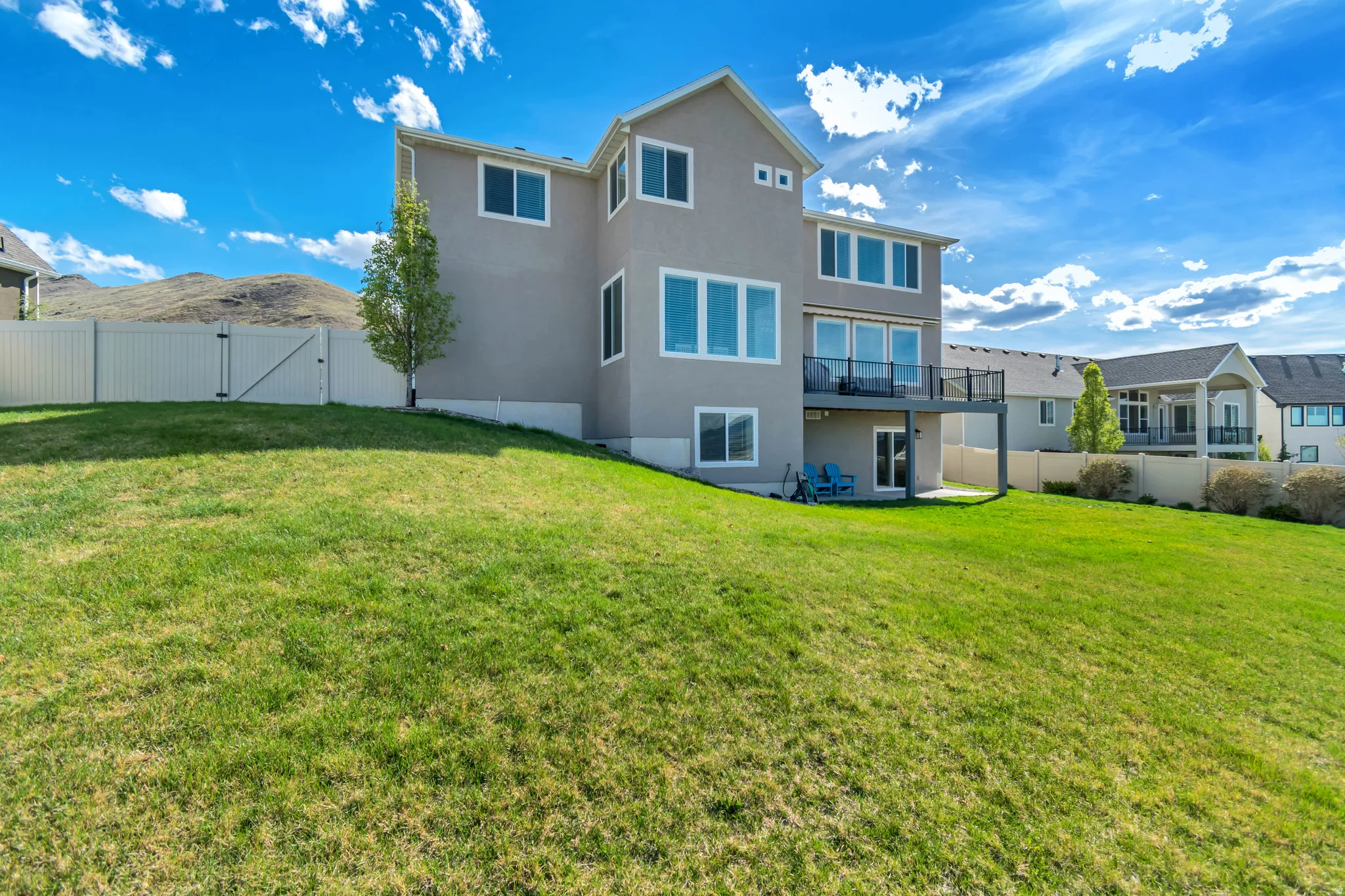 Rear view of property with a gate, stucco siding, a fenced backyard, and a patio area