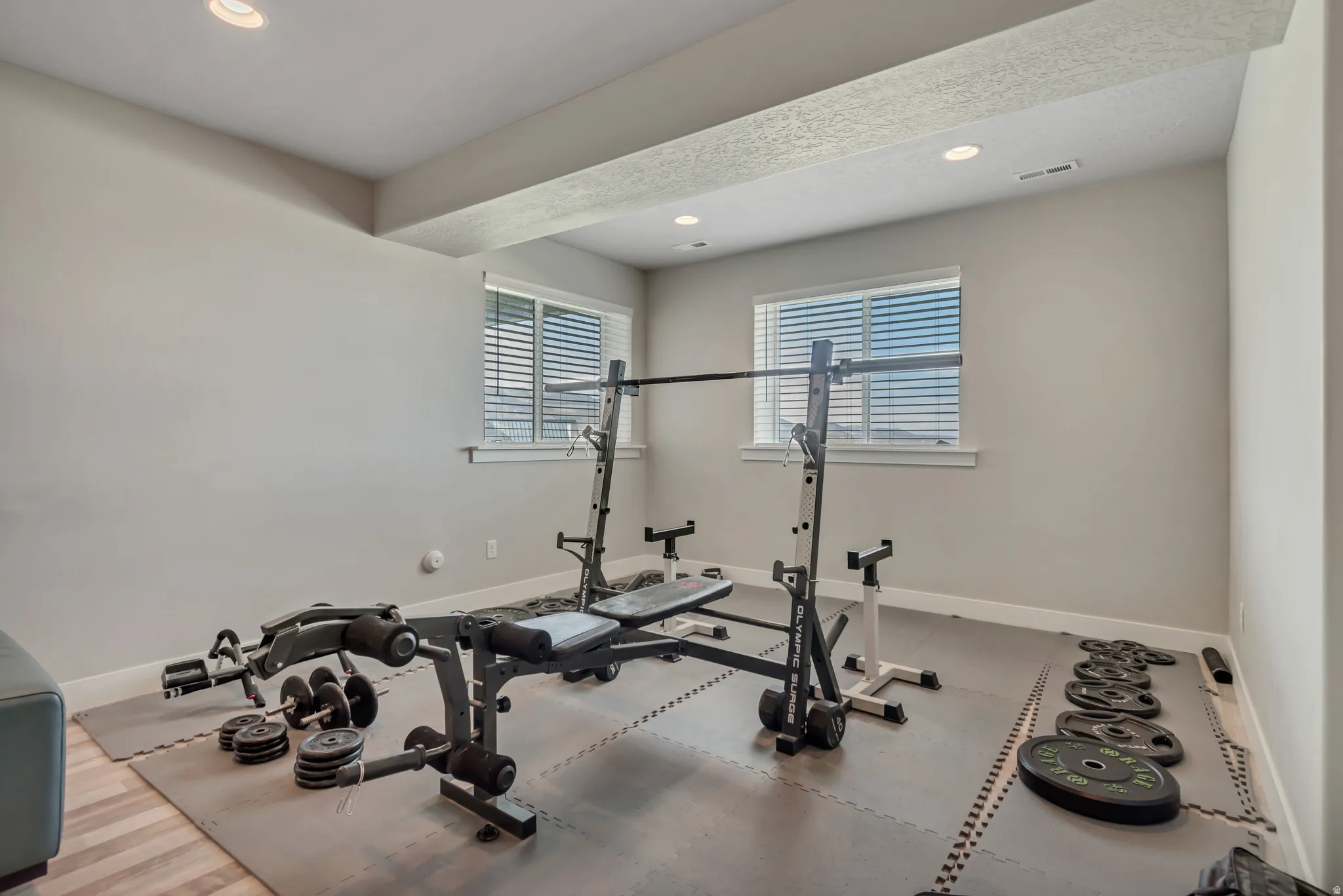 Exercise room with baseboards and recessed lighting