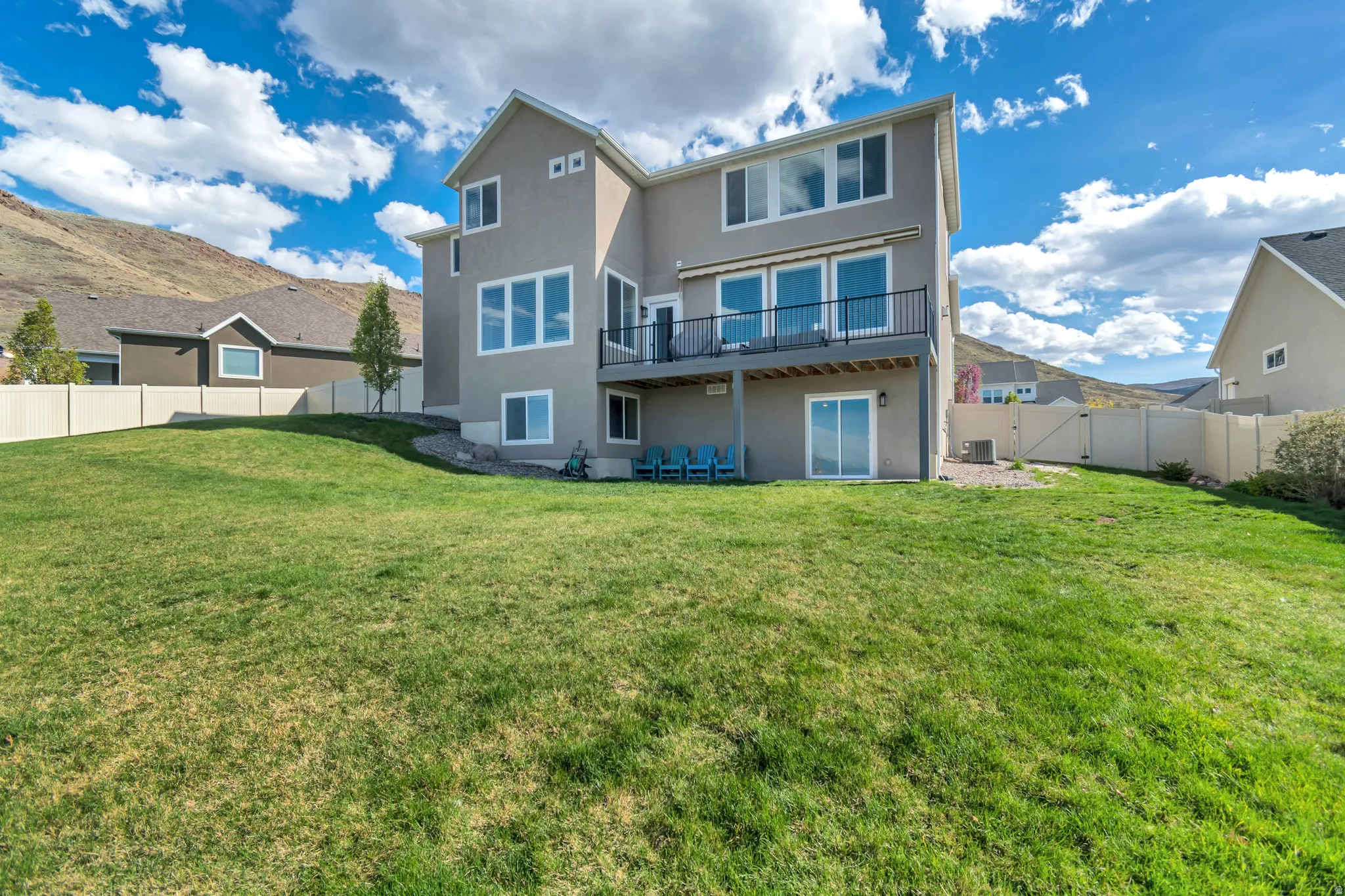 Back of property with stucco siding, a gate, a fenced backyard, and a patio