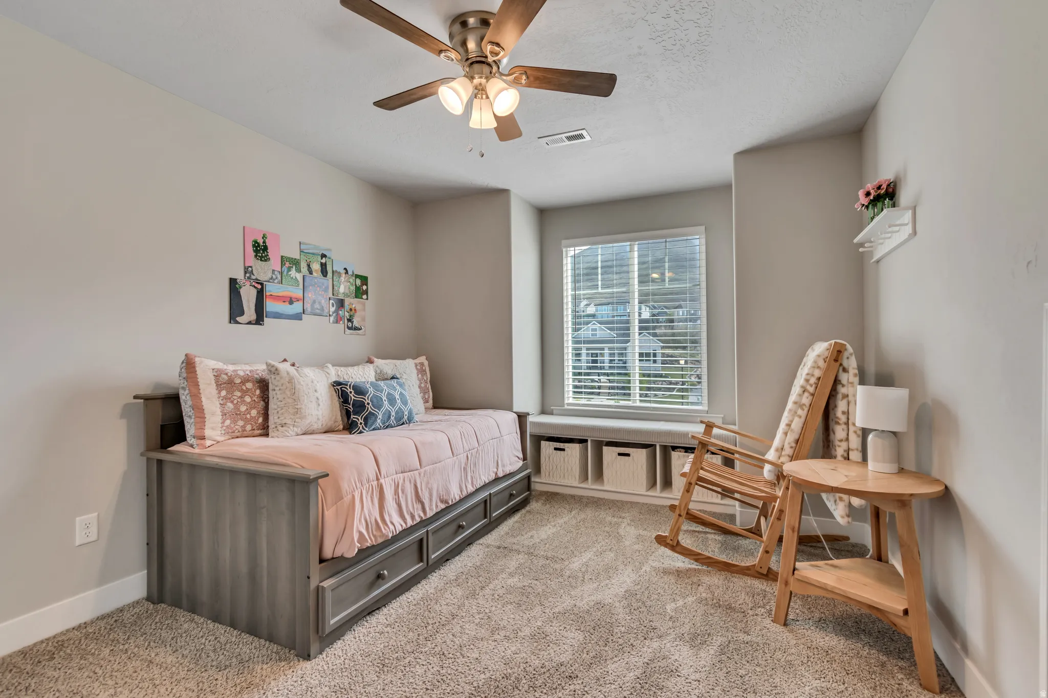 Bedroom with light colored carpet, ceiling fan, and a textured ceiling