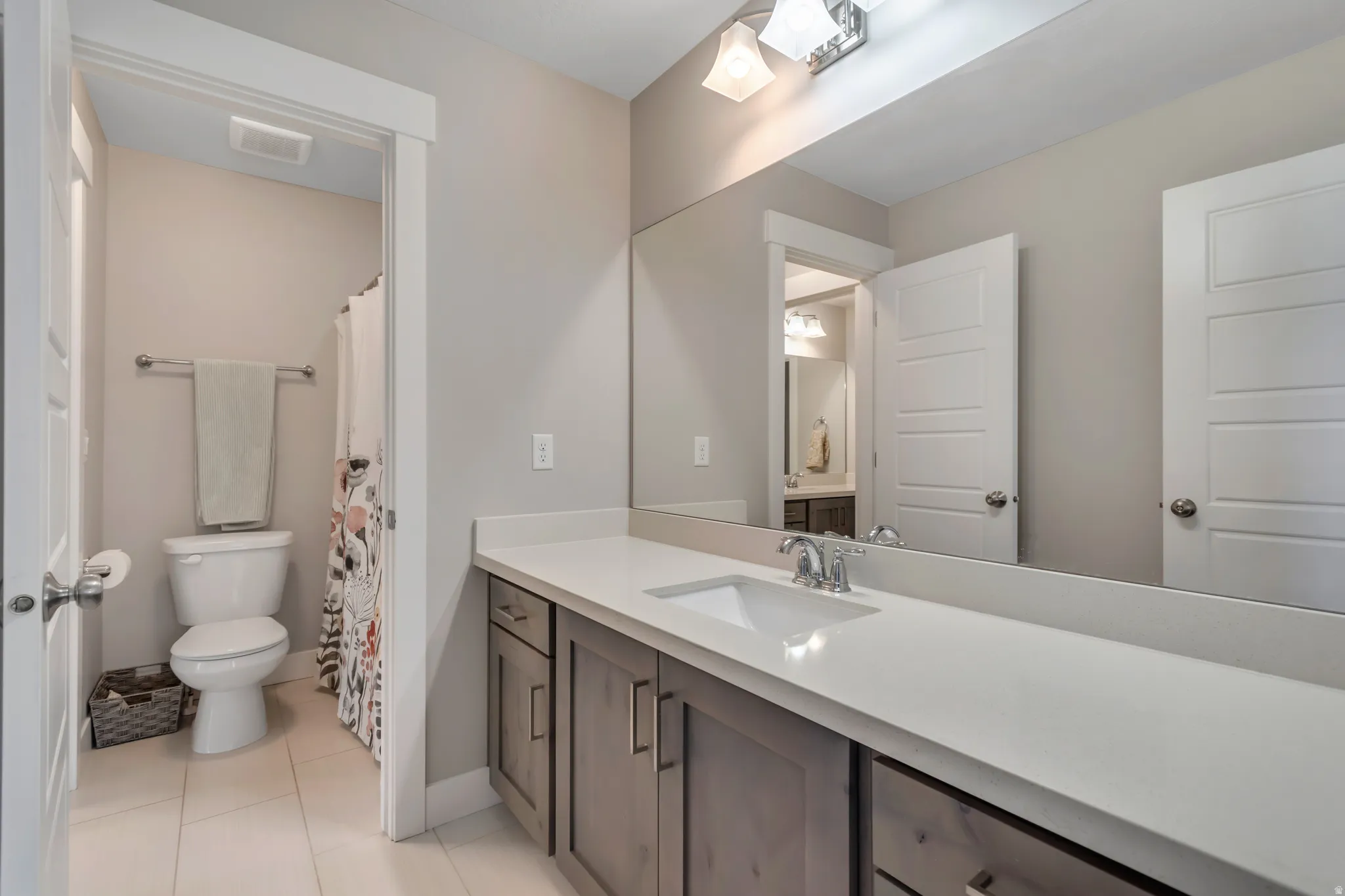 Bathroom featuring vanity, a shower with curtain, and light tile patterned floors