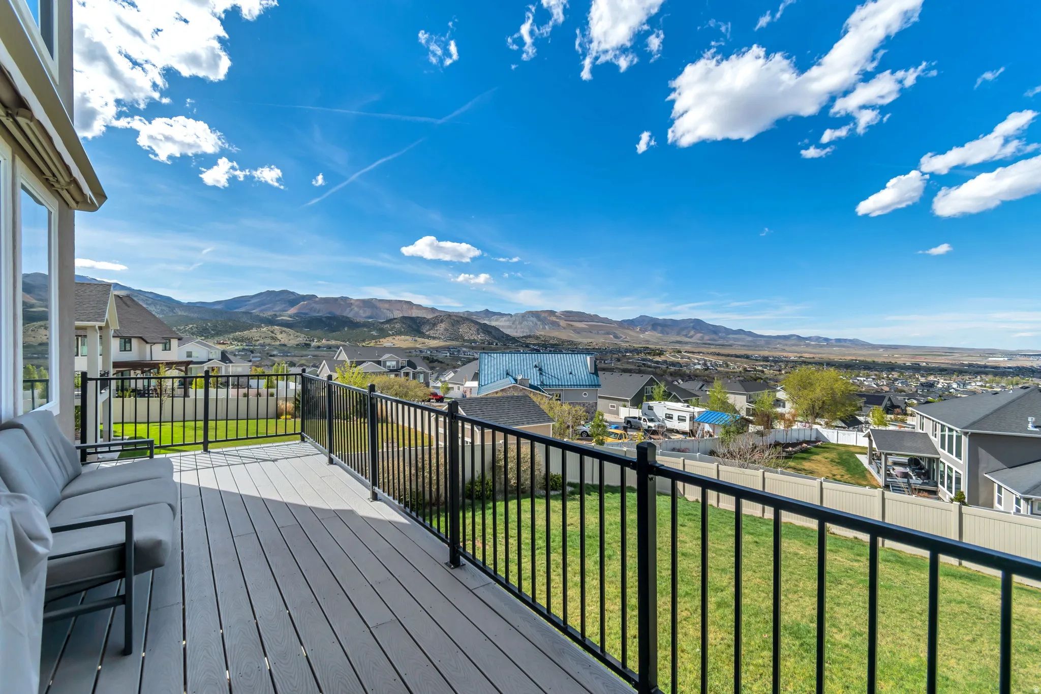 Deck with a residential view, a yard, and a mountain view